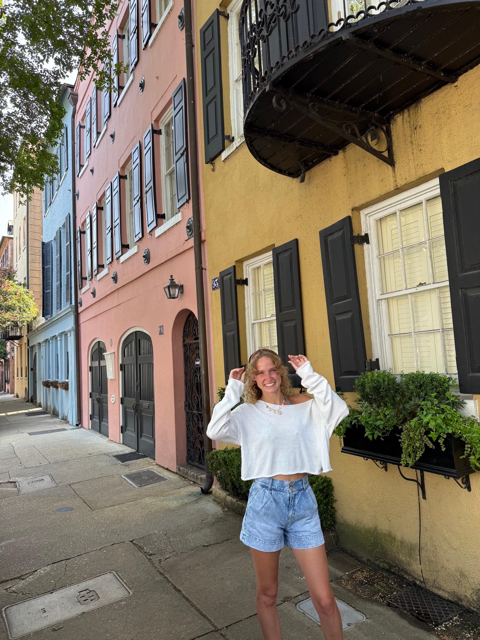 Brekyn Kok on a colorful street, smiling with her hands in her hair